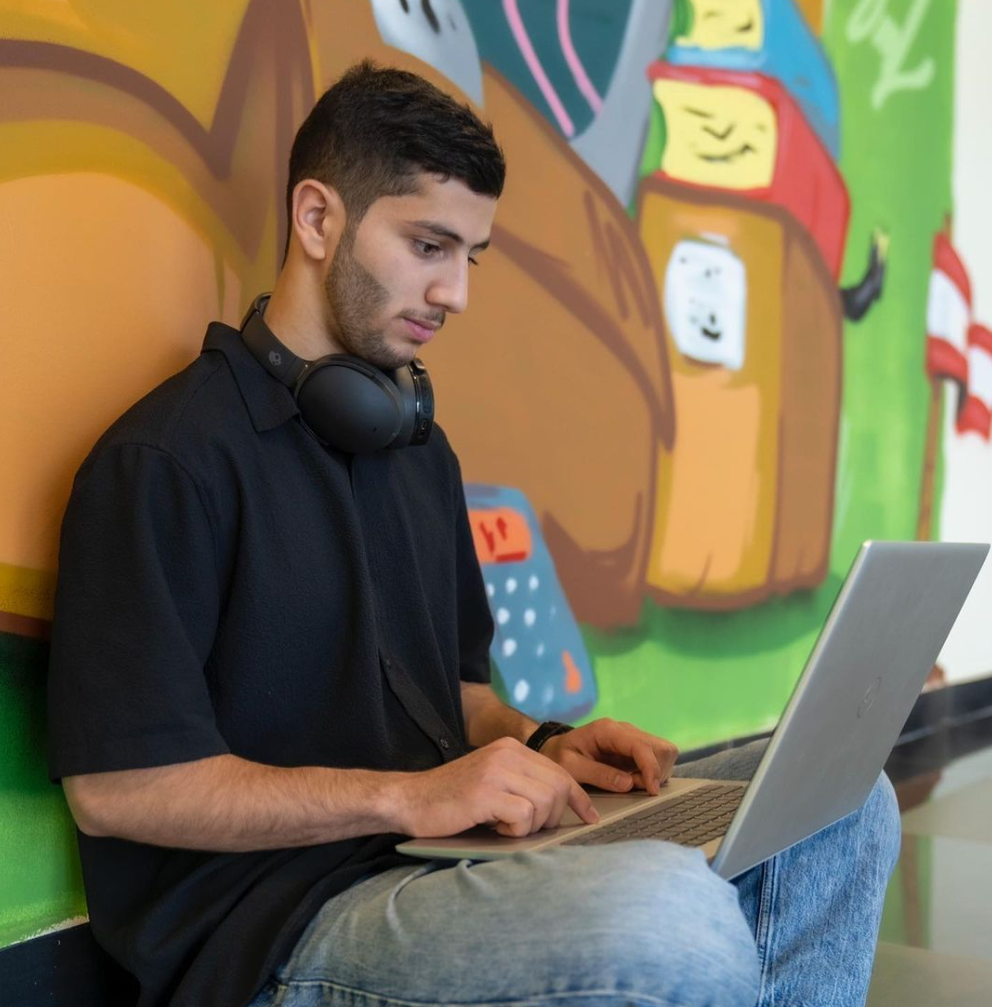 Student studying on a laptop in a Business Program at Canadian College Kuwait (CCK)